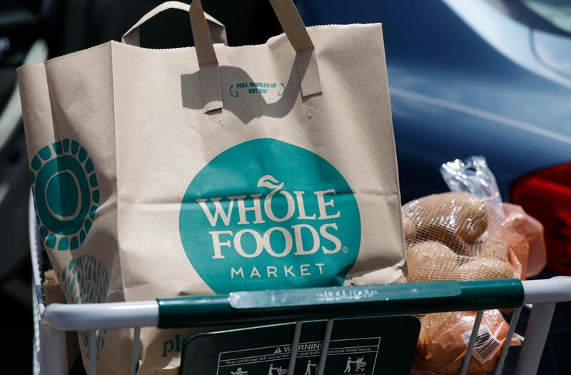 FILE - In this Friday, June 16, 2017, file photo, groceries from Whole Foods Market sit in a cart before being loaded into a car, outside a store in Jackson, Miss. On Wednesday, Aug. 23, 2017, Whole Foods shareholders will be voting on whether to approve Amazonâ€™s $13.7 billion takeover bid of the organic grocer. (AP Photo/Rogelio V. Solis, File)