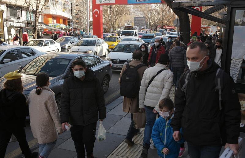 People wearing masks to help protect against the spread of coronavirus, walk along a busy shopping street, in Ankara, Turkey, Wednesday, Dec. 30, 2020. A first batch of vaccines developed by Chinese biopharmaceutical company Sinovac have arrived in Turkey, after a two-week delay. A plane carrying 3 million doses of the CoronaVac vaccine landed in the capital Ankara early on Wednesday.(AP Photo/Burhan Ozbilici)