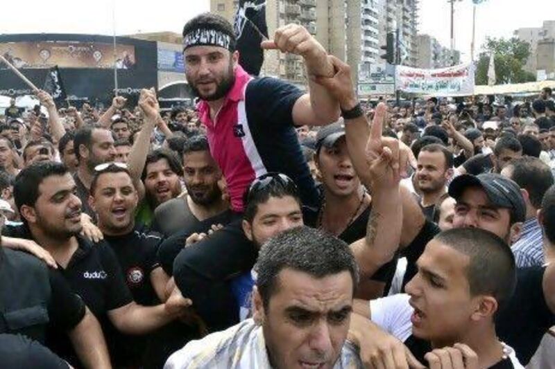 Shadi Al Mawlawi, centre, a Sunni supporter of Syria's rebels, is accused by Lebanese authorities of belonging to a terrorist organisation. His arrest triggered large demonstrations in Tripoli and fighting between fundamentalist Sunnis and Alawites.