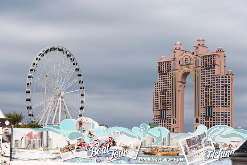 The Marina Eye Ferris wheel and Fairmont Marina hotel from behind a billboard along the Corniche. Khushnum Bhandari / The National