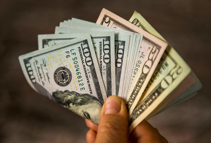 Unrecognizable mature man holding US Dollar bills. Getty Images