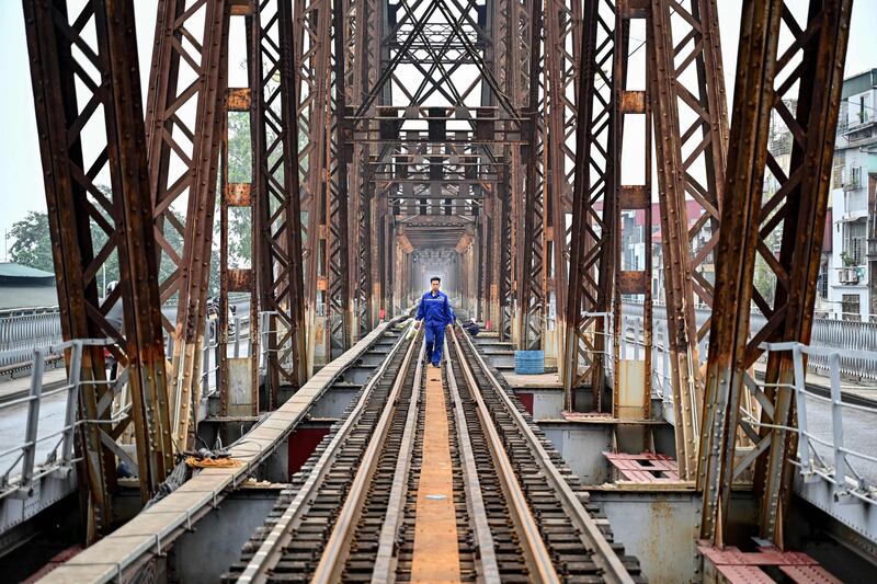 A worker walks along the middle of the track during maintenance work on Long Bien bridge in Hanoi, Vietnam. AFP