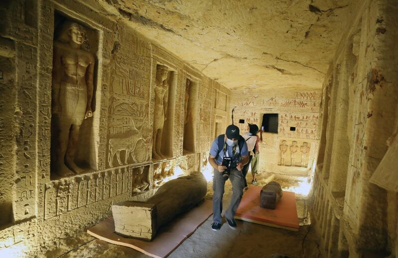 People inspect the sarcophagus on display after they were discovered at Saqqara Necropolis, Giza.  EPA