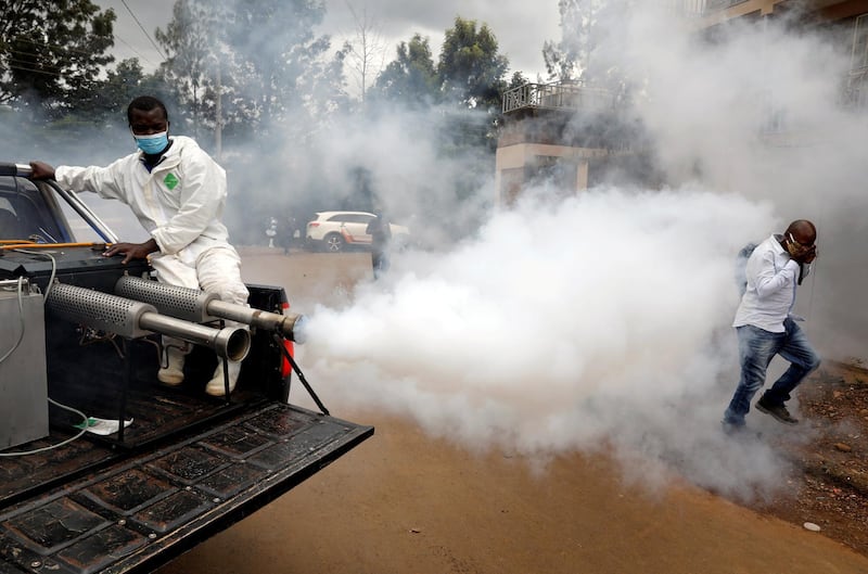 A man walks through smoke generated by Nairobi municipality worker in an effort to fight against the spread of the coronavirus disease in the Kawangware neighborhood of Nairobi, Kenya. Reuters