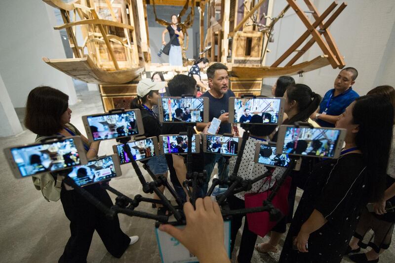 A reporter  live broadcasts using 10 smartphones at the first Sculpture Projects Pingyao art festival in Jinzhong, Shanxi province, China. Reuters