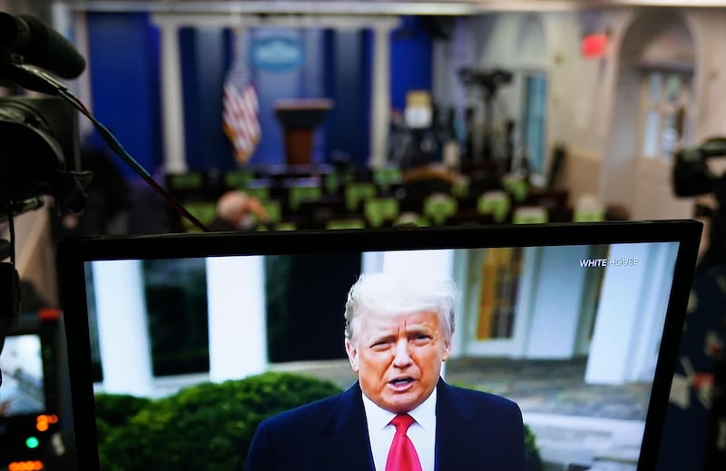 US President Donald Trump is seen on TV from a video message released on Twitter addressing rioters at the US Capitol, in the Brady Briefing Room at the White House in Washington, DC. AFP