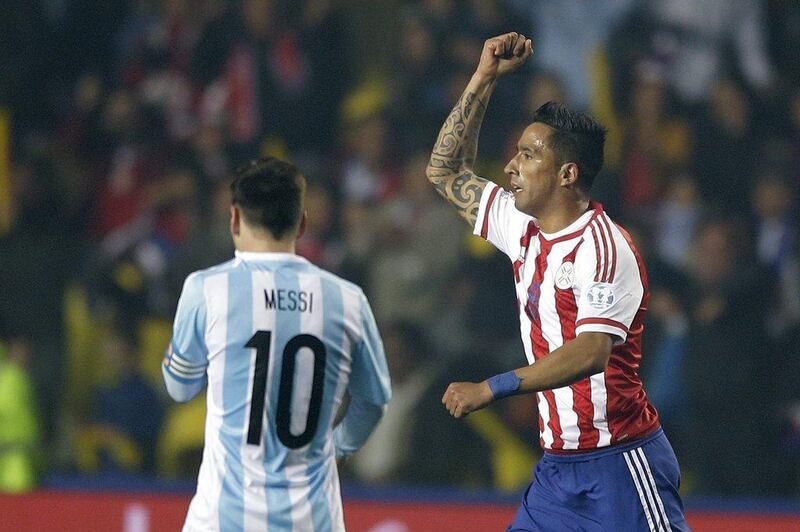 Paraguay's Lucas Barrios, right, celebrates after scoring against Argentina to make it 2-1 in the first half as he runs by Lionel Messi during Tuesday's Copa America semi-final. Ricardo Mazalan / AP