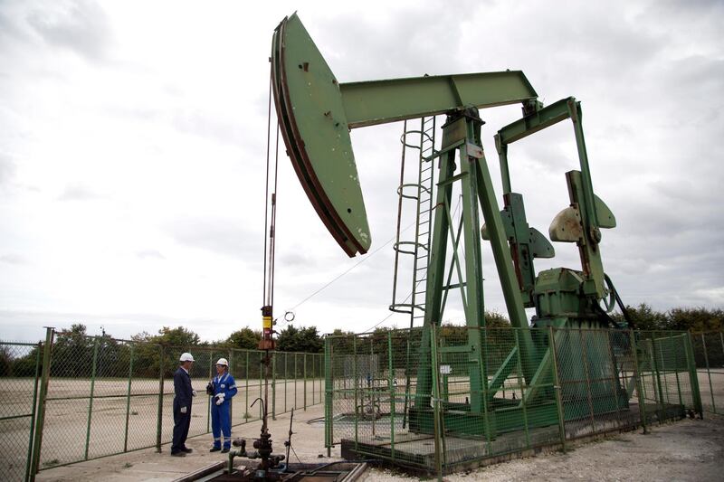 Thierry Oger, right, a production manager for Canadian based Vermilion oil company, and Jean-Pascal Simard, head of public affairs, warcht an oil rig, Wednesday, Sept. 6, 2017 in Andrezel, south east of Paris . France's government has unveiled a law to ban all production and exploration of oil and natural gas by 2040 on the country's mainland and overseas territories. The move is largely symbolic, however, as France's oil and gas production represents just 1 percent of national consumption _ the rest is imported. (AP Photo/Thibault Camus)