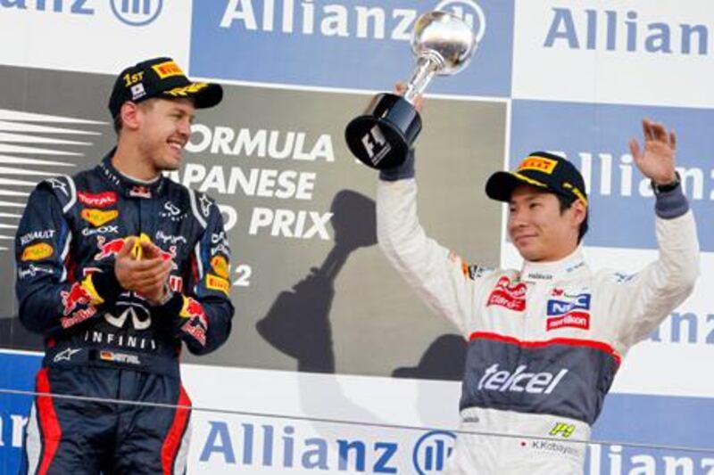 Kamui Kobayashi is congratulated by Sebastian Vettel as he celebrates his podium finish in the Japanese Grand Prix