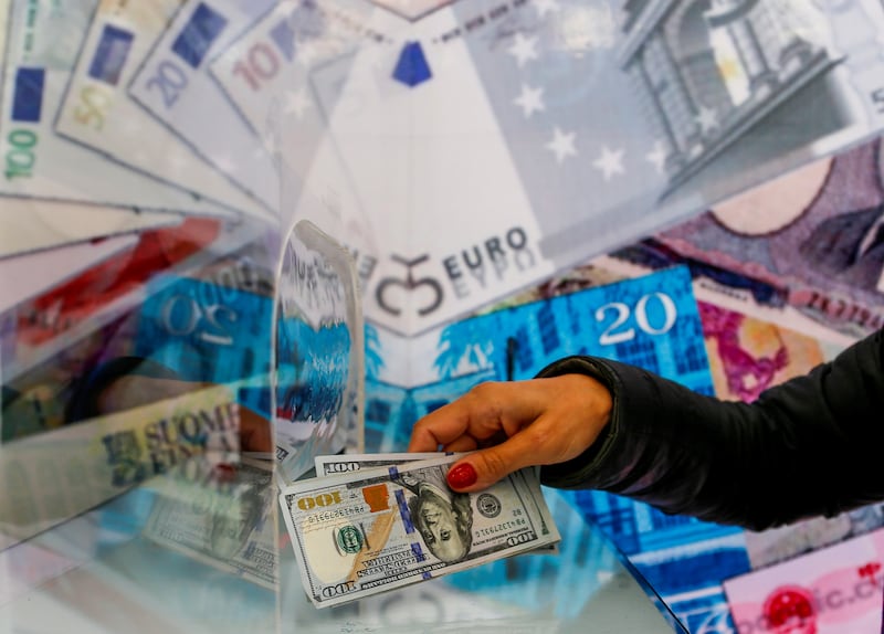 A money changer sells US dollar bills at a currency exchange office. The global economy is expected to register 'stable growth' in 2023, according to Moody's Investor Service. Reuters