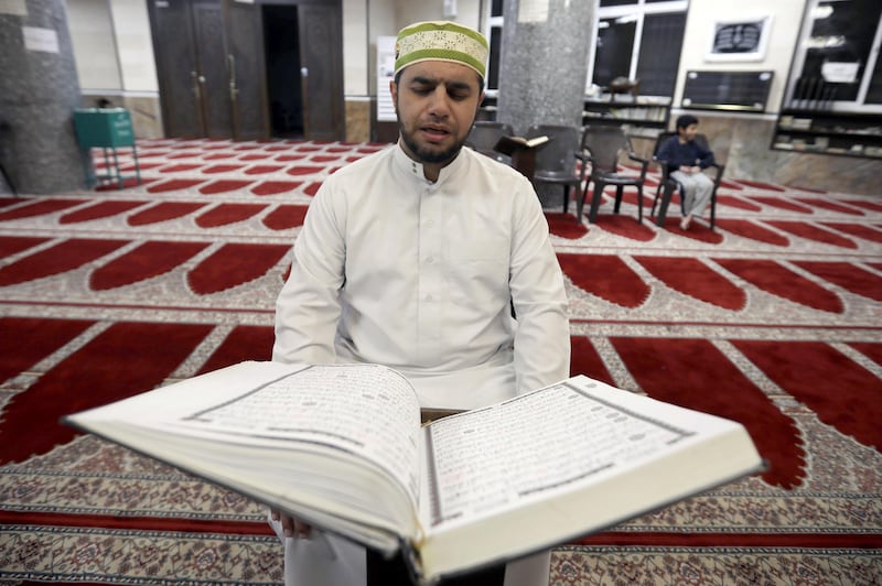 A Jordanian Imam Ahmad Al-Harasis, reads the Koran at empty Abdullah Ben Sallam mosque during the holy fasting month of Ramadan as prayers by worshippers in the holy places are suspended due to concerns about the spread of the coronavirus disease (COVID-19), in Amman, Jordan April 26, 2020. Picture taken April 26, 2020. REUTERS/Muhammad Hamed