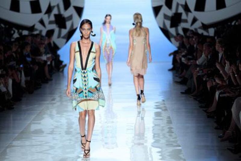 Models present an evening gown from Roberto Cavalli, left, and looks from Etro, above, at Milan Fashion Week.