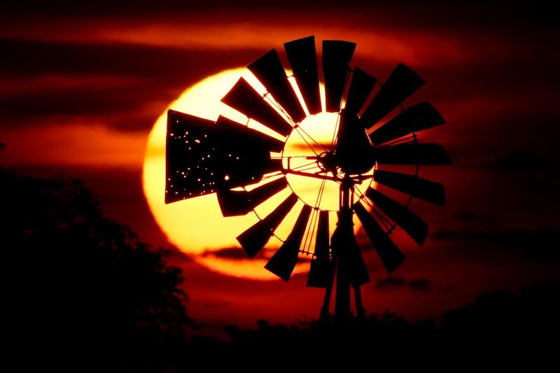 The sun sets behind a tattered windmill near Tappen in the US. AP Photo