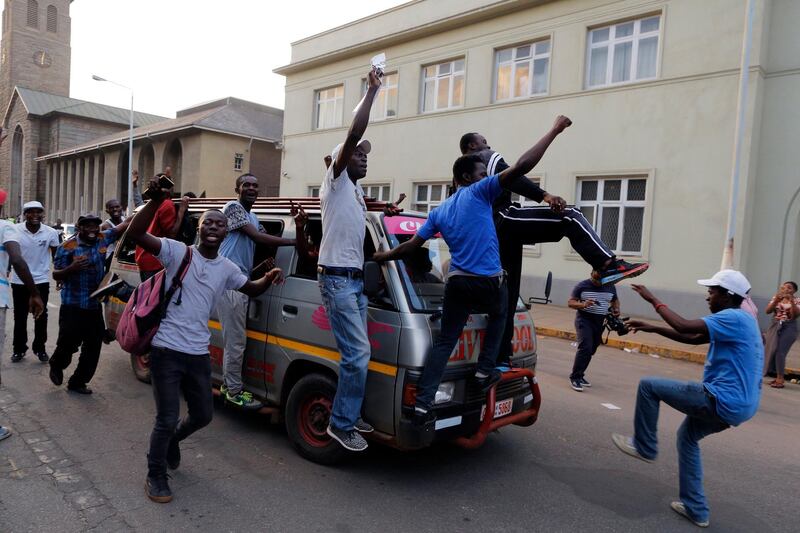 People celebrate outside parliament after hearing the news that president Robert Mugabe had resigned in Harare. Kim Ludbrook / EPA