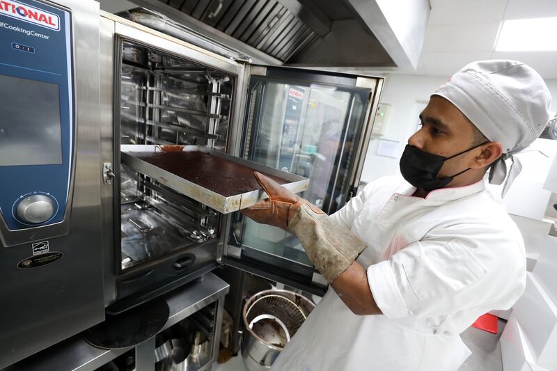 Chef de partie Gayan takes cake out of the oven.