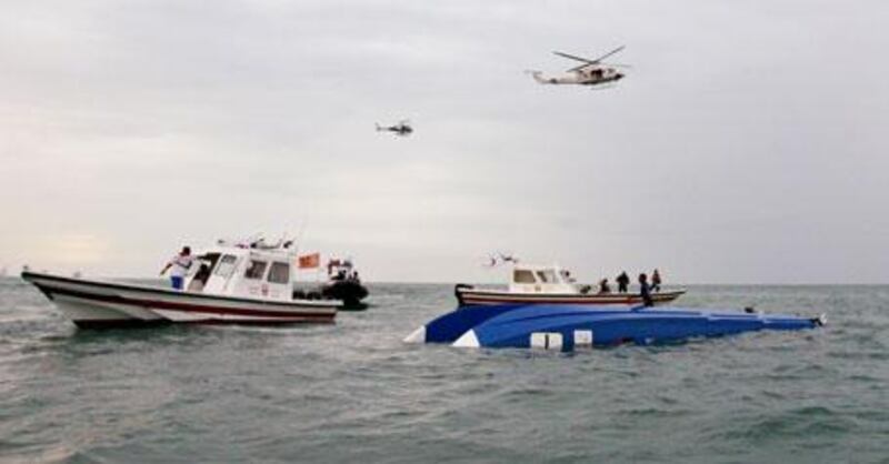 Boats and helicopters hover near the upended Victory 1 racing boat, which crashed during a competition on Friday, killing Mohammed al Mehairi and Jean-Marc Sanchez.
