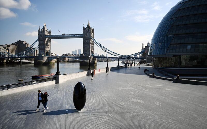 Pedestrians walk through the City of London in London as lockdown restrictions continue. EPA