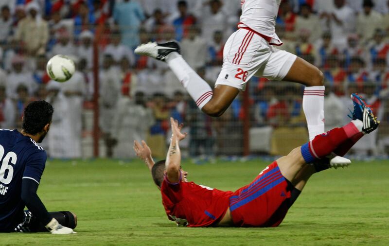 Dubai, United Arab Emirates - September 9, 2012.  Al Shaab ( number 29 ) went down as Al Sharjah ( number 26 ) tries to jump over him and Al Sharjah ( number 96 ) goal keeper looks on.  ( Jeffrey E Biteng ? The National )