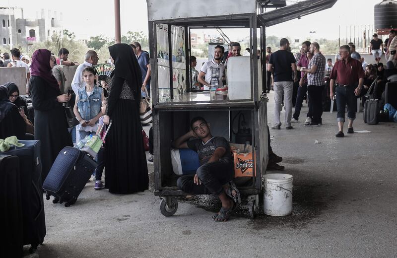 Palestinians wait for travel permits to cross into Egypt through the Rafah border crossing after it was partially opened by Egyptian authorities, in Rafah in the southern Gaza Strip, on August 16, 2017. Said Khatib / AFP Photo