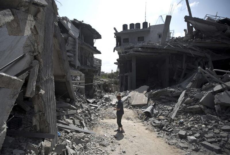 A Palestinian man stands amid the rubble of buildings following an Israeli military strike in the Gaza Strip last month. Mahmud Hams / AFP