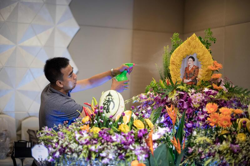 A worker sprays water on an elaborate fruit and vegetable decoration adorned with the photograph of Thailand's Queen Sirikit during a fruit and vegetable carving competition in Bangkok. Robert Schmidt / AFP