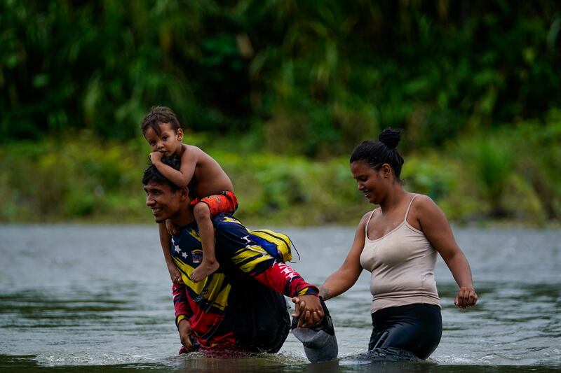 Venezuelan migrants wade across the Tuquesa River after trekking through the Darien Gap in Bajo Chiquito, Panama. AP