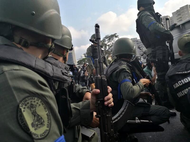 A group of National Guard members supporting Mr. Guaido gather during a military uprising near the La Carlota base. Bloomberg