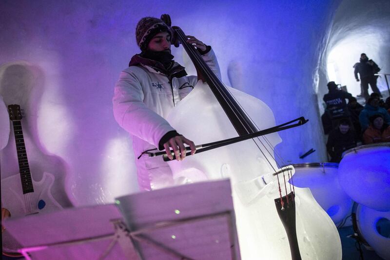 A musician performs with an ice double bass. AFP