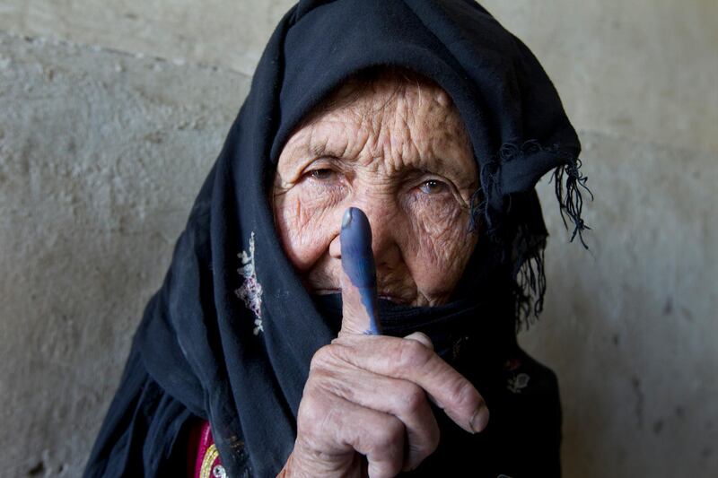 KABUL, AFGHANISTAN - SEPTEMBER 18:  An elderly Afghan woman shows off her inked finger to the camera after she made it to the polls to cast her vote September 18, 2010 in Kabul, Panjshir, Afghanistan. More than 2,500 candidates will contest for 249 seats in the lower house of the Afghan parliament in the country's second election.The Taliban warned voters to boycott the polls threatening violence to disturb the election process. (Photo by Paula Bronstein/Getty Images)