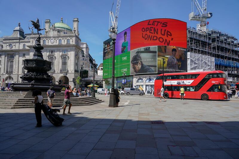 People walk through a relatively quiet Piccadilly Circus in London. AP