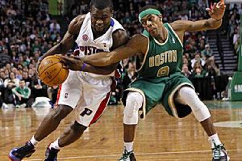 The Boston Celtics guard Rajon Rondo, right, reaches in to knock the ball away from Pistons's Will Bynum.