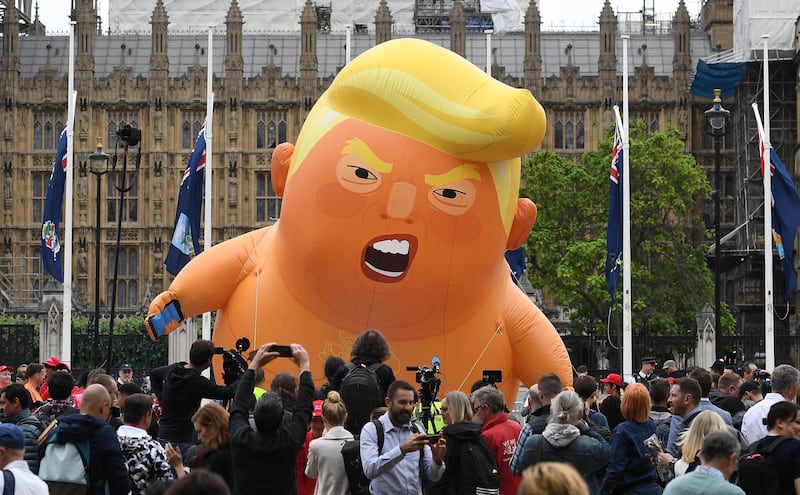 epaselect epa07624037 Anti Trump protesters with a Trump baby blimp flying over Parliament Square gather for a protest against US President Donald J. Trump State visit to the UK in London, Britain, 04 June 2019. US President Trump and First Lady Trump are on a three-day official visit to Britain.  EPA/ANDY RAIN