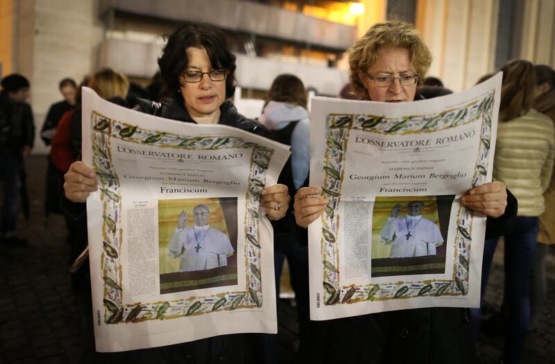 Women read a special edition of L'Osservatore Romano newspaper, which carries a photograph of the newly elected Pope Francis, March 2013. Getty Images