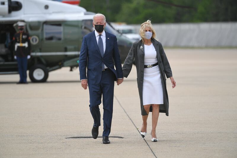Jill Biden, wearing a white dress and grey duster coat, boards Marine One with President Joe Biden on May 3, 2021. AFP