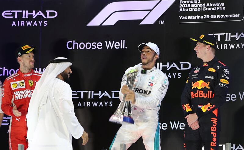 Formula One F1 - Abu Dhabi Grand Prix - Yas Marina Circuit, Abu Dhabi, United Arab Emirates - November 25, 2018  Mercedes' Lewis Hamilton celebrates winning the race on the podium with second place Ferrari's Sebastian Vettel and third place Red Bull's Max Verstappen   REUTERS/Ahmed Jadallah