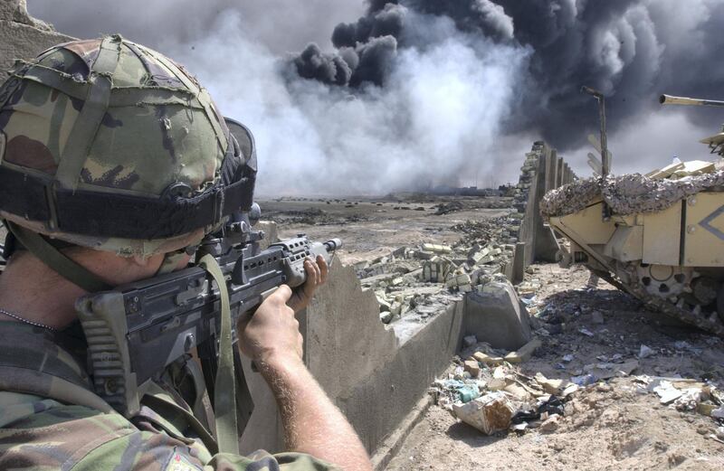 Operation Telic: British Forces In Iraq, 2003, At Bridge Four on the outskirts of Basra, a soldier of 1st Battalion, The Irish Guards looks for possible Iraqi enemy positions as Royal Engineer technicians prepare to cap one of the burning oil wells within the city of Basra, 3 April 2003. (Photo by Giles Penfound/ Crown Copyright. Imperial War Museums via Getty Images)