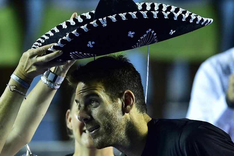 Argentina's Juan Martin del Potro wears a traditional Mexican mariachi hat while holding the winning trophy (out of frame) after defeating Kevin Anderson of South Africa at the Mexico ATP Open men's single final in Acapulco, Guerrero state on March 3, 2018. / AFP PHOTO / PEDRO PARDO