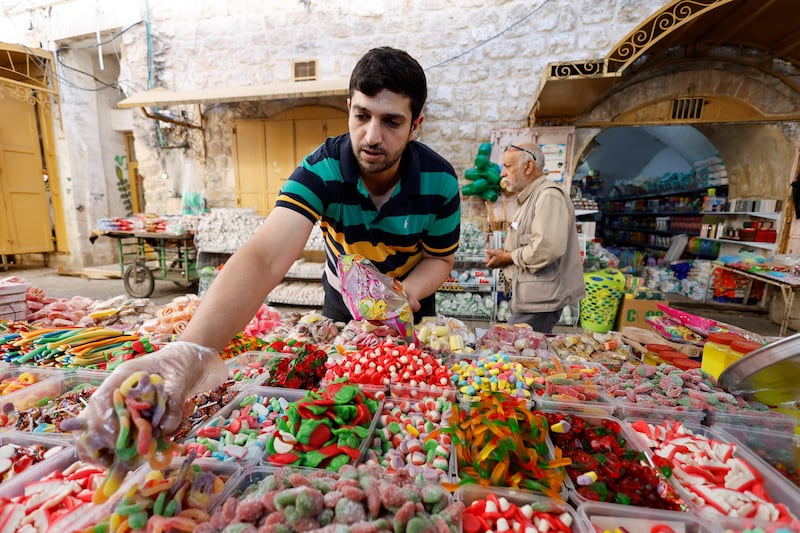 A Palestinian stall-holder arranges sweets in the old city in Hebron in the Israeli-occupied West Bank. Reuters