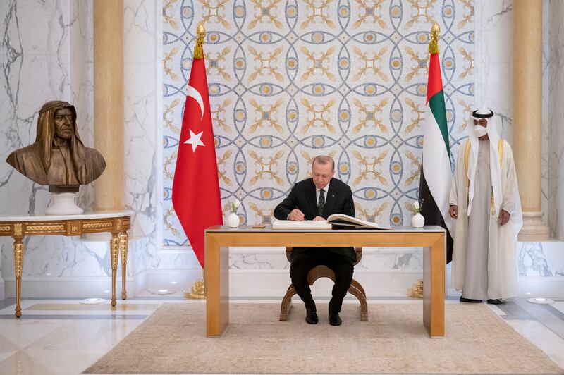 President Erdogan signs the guest book at Qasr Al Watan as Sheikh Mohamed looks on.