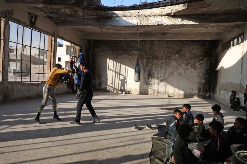 Displaced Syrian boxer Ahmad Dwara trains youths inside a damaged building in the town of Atareb in the rebel-held western countryside of Syria's Aleppo province. AFP