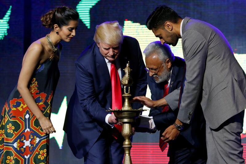 Republican Hindu Coalition chairman and a member of Hindus for Trump Shalabh Kumar (second right) helps the presidential candidate light a ceremonial diya lamp at a Bollywood-themed charity concert on October 15, 2016. Jonathan Ernst/Reuters