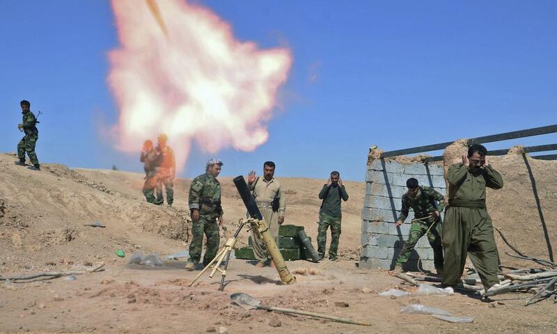 Kurdish peshmerga fighters fire a mortar during clashes with ISIL militants in the Al Zerga area near Tikrit city, in Salahuddin province on October 8, 2014. UK troops are in Erbil to train Kurdish fighters on how to use the heavy machine guns Britain supplied in September. Reuters
