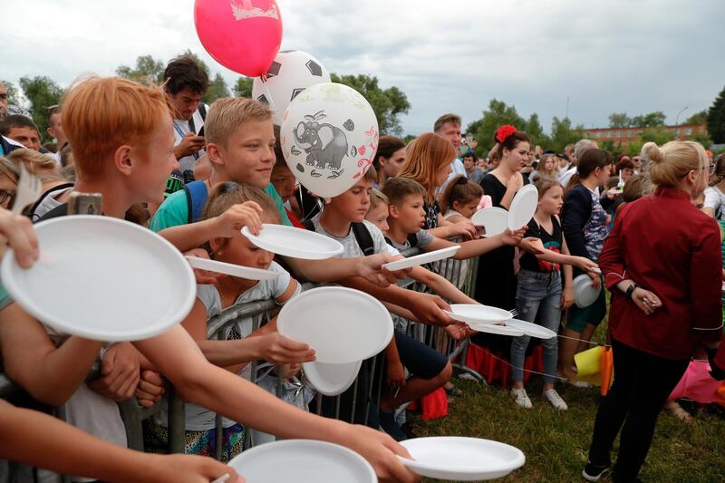 Children wait for cake at a celebration to mark Lionel Messi's birthday near Argentina's training camp base at the 2018 World Cup in Bronnitsy, Russia. AP