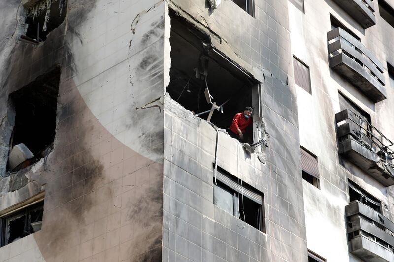 A man checks the damage inside an apartment building that was hit in the Kfar Souseh district of Damascus. AFP