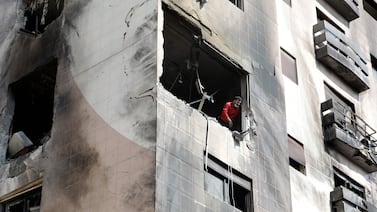 A man checks the damage inside an apartment building that was hit in the Kfar Souseh district of Damascus. AFP