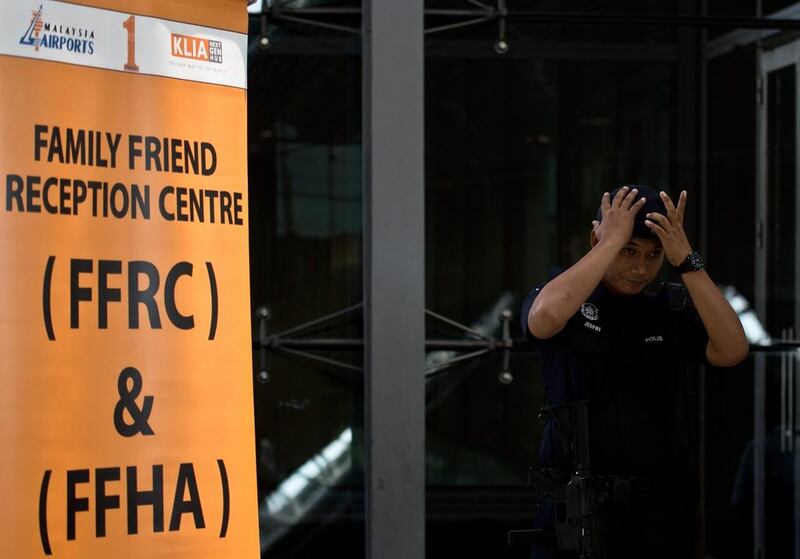 A Malaysian policeman stands guard outside a reception centre for family and friends at the Kuala Lumpur International Airport. AFP