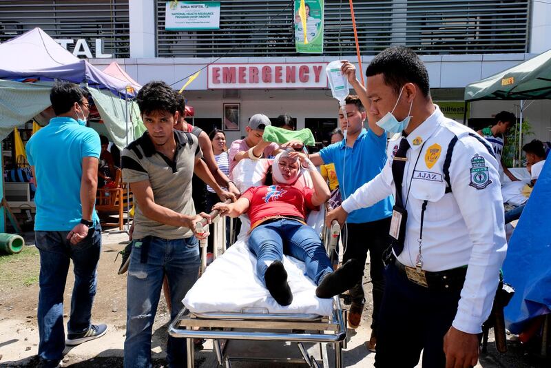 A woman is transferred to another hospital after she was injured following a quake that hit Digos, Davao del Sur, southern Philippines on Thursday Oct. 31, 2019. The third strong earthquake this month jolted the southern Philippines on Thursday morning, further damaging structures already weakened by the earlier shaking. (AP Photo/Romer S. Sarmiento)