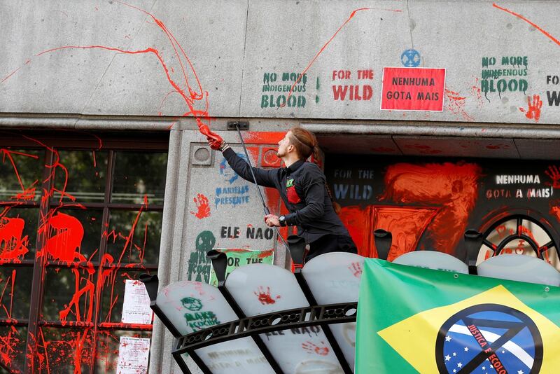 An activist splashes red paint over the embassy's facade during Extinction Rebellion climate change protest in front of Brazilian Embassy in London, Britain, August 13, 2019. REUTERS/Peter Nicholls