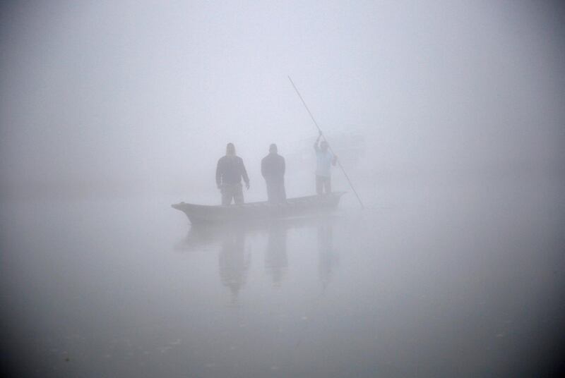 People ride on a boat on the Rapti River during a foggy winter morning in Sauraha, Chitwan, Nepal. Navesh Chitrakar / Reuters
