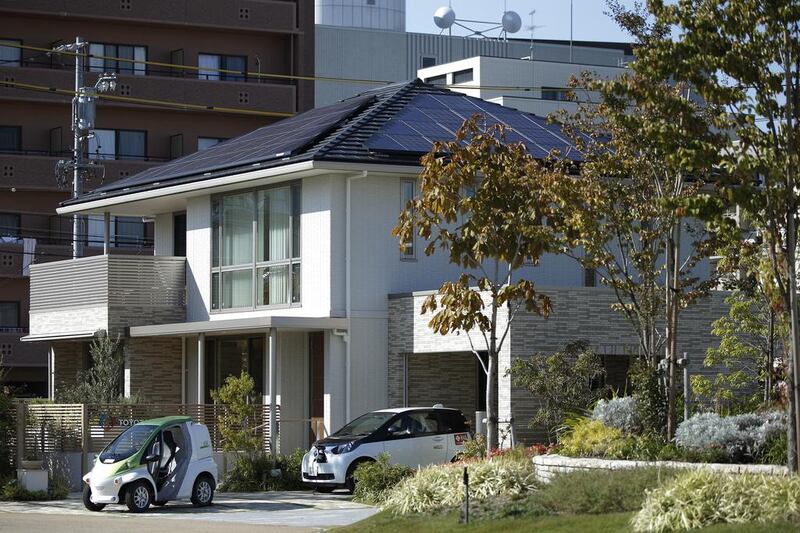 Above, a Toyota super-compact electric vehicle, left, and a Toyota compact electric vehicle parked outside a model smart home in Toyota City. Toyota has issued a $1.75 billion green asset-backed bond — backed by car leases and loans that are earmarked for future green vehicles. Kiyoshi Ota / Bloomberg News